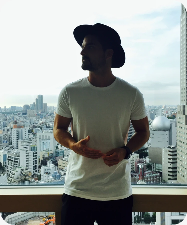 Eric in a hat against the Tokyo skyline