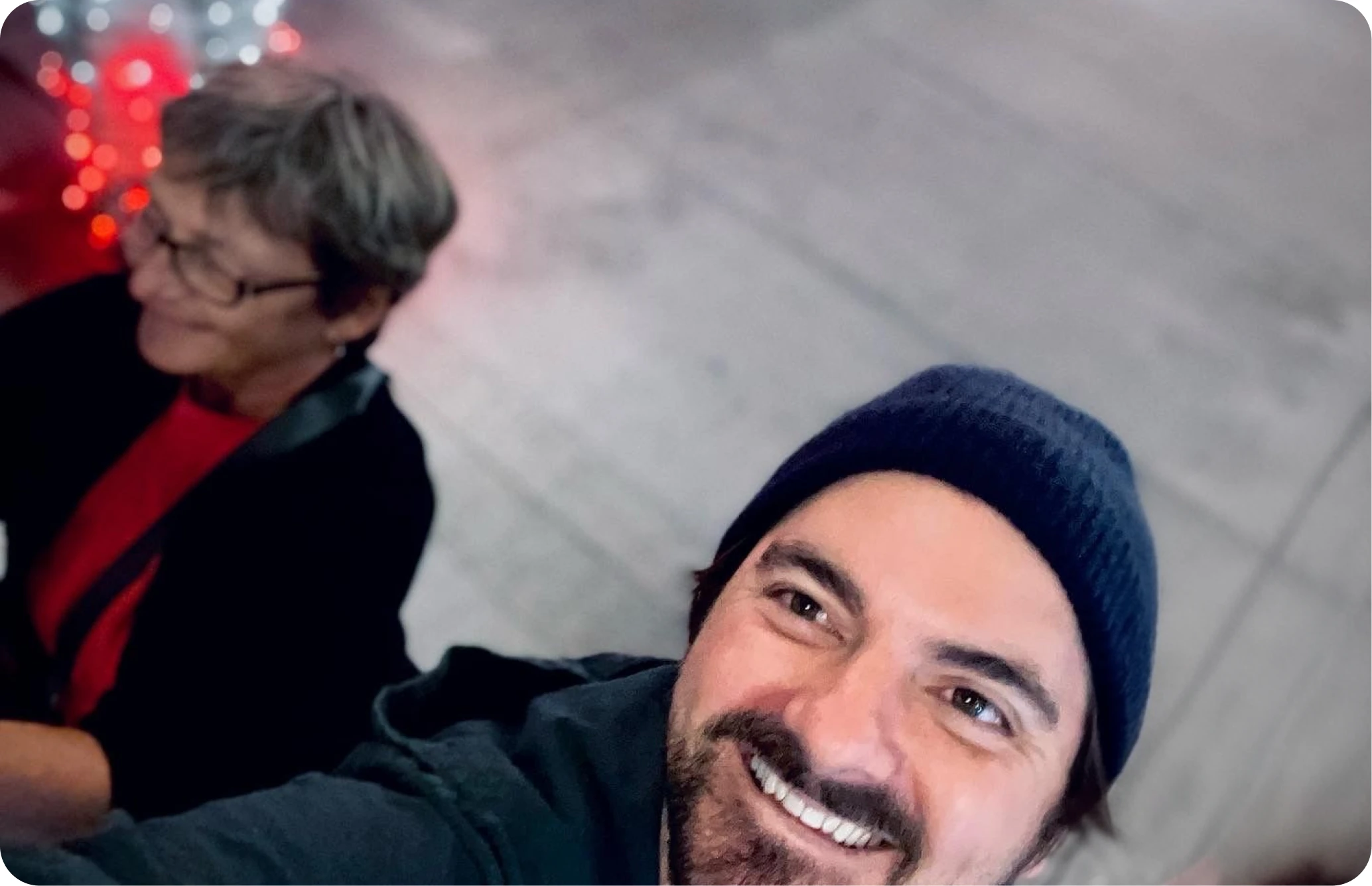Eric smiling in a beanie beside family