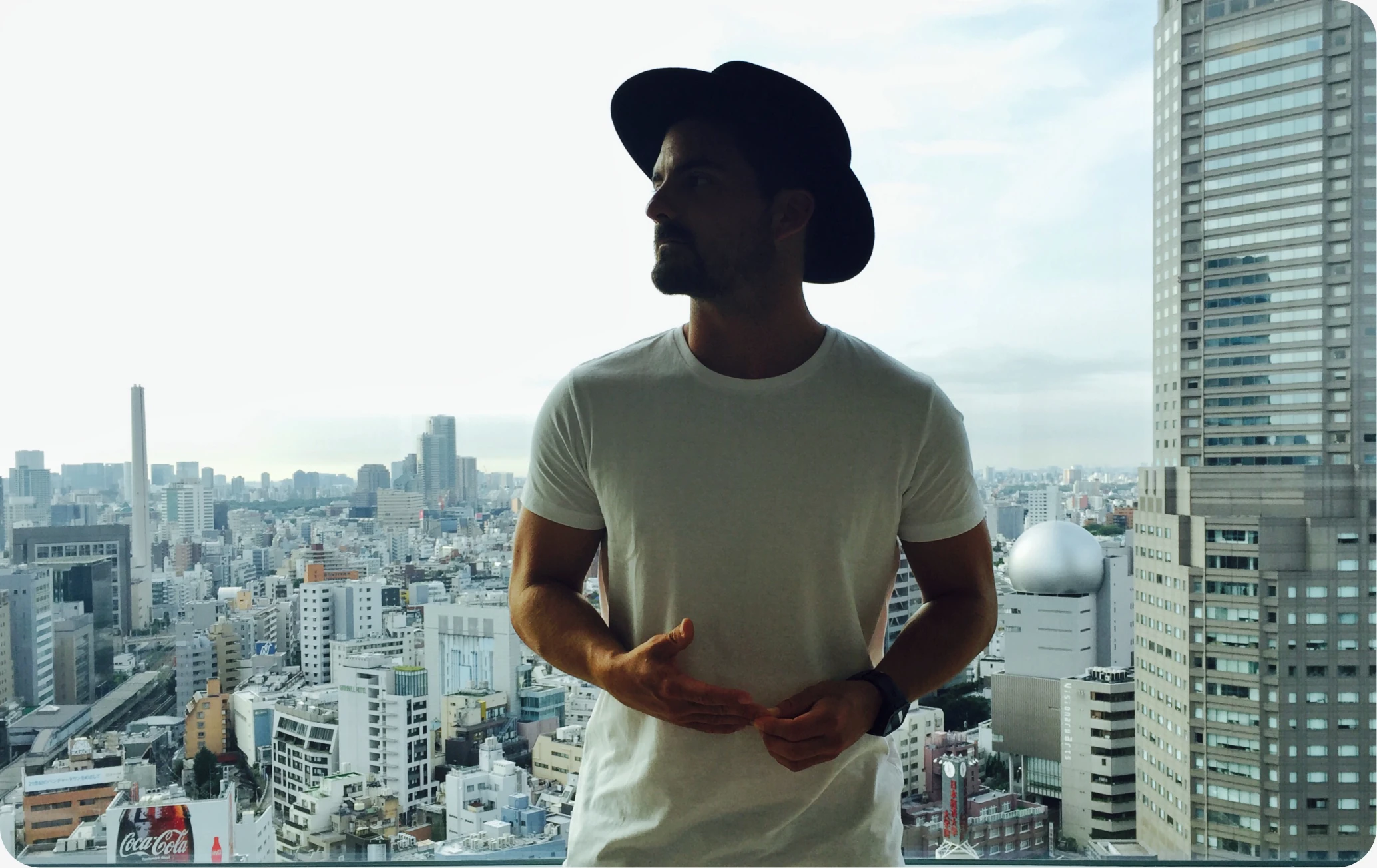 Eric in a hat against the Tokyo skyline
